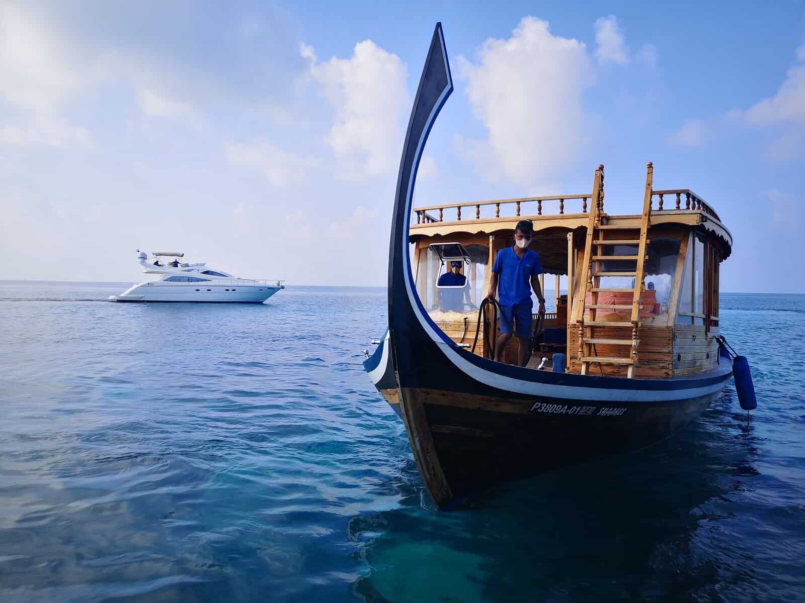 A traditional dhoni on clear water in the Maldives