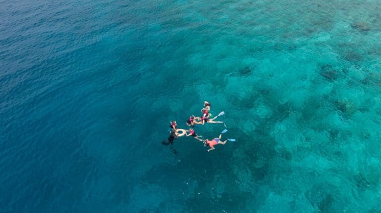 Snorkellers over a turquoise reef in the Maldives