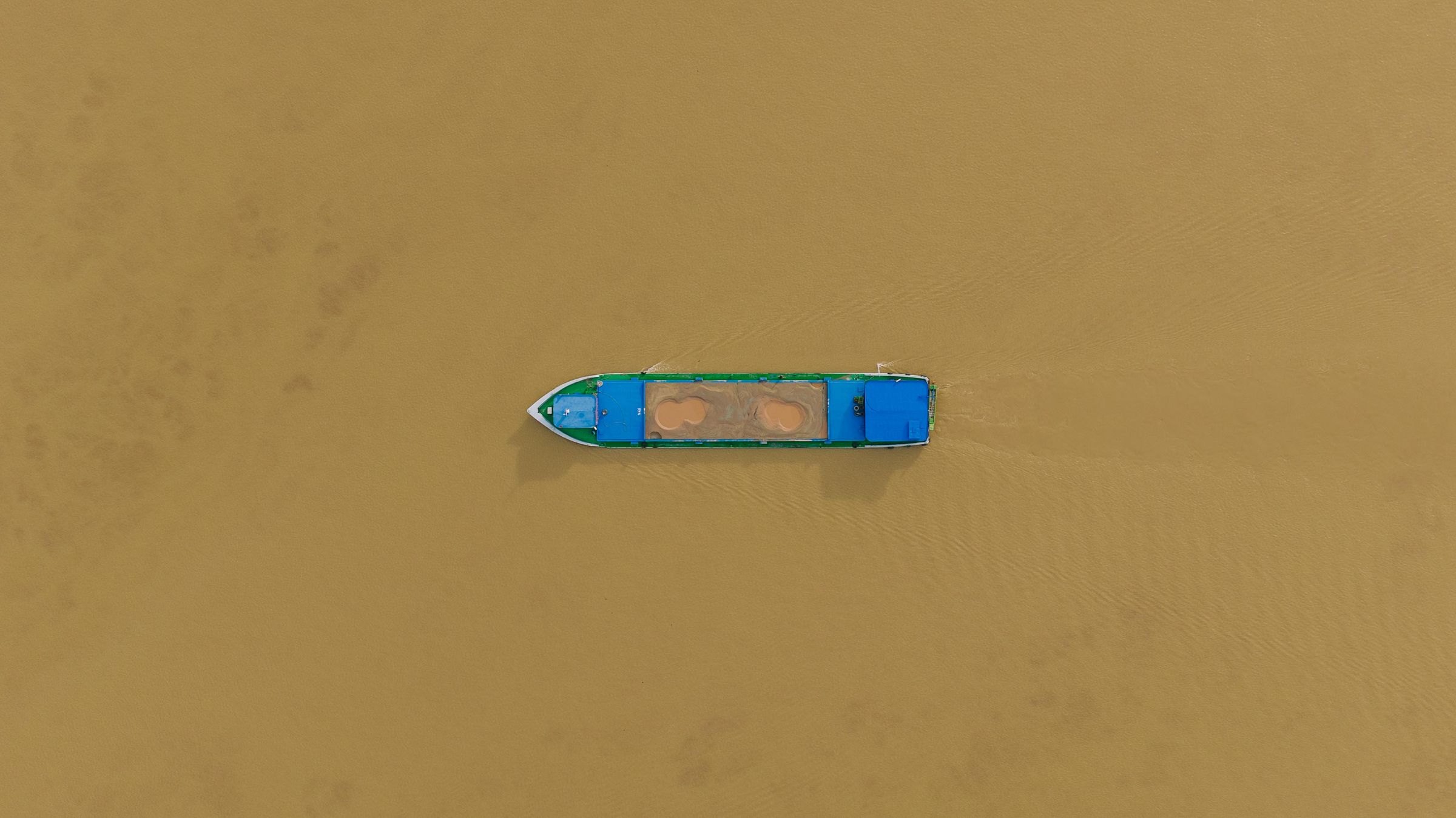 A boat on the brown waters of the Mekong