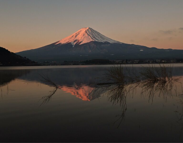 Mount Fuji reflected in a lake at dawn