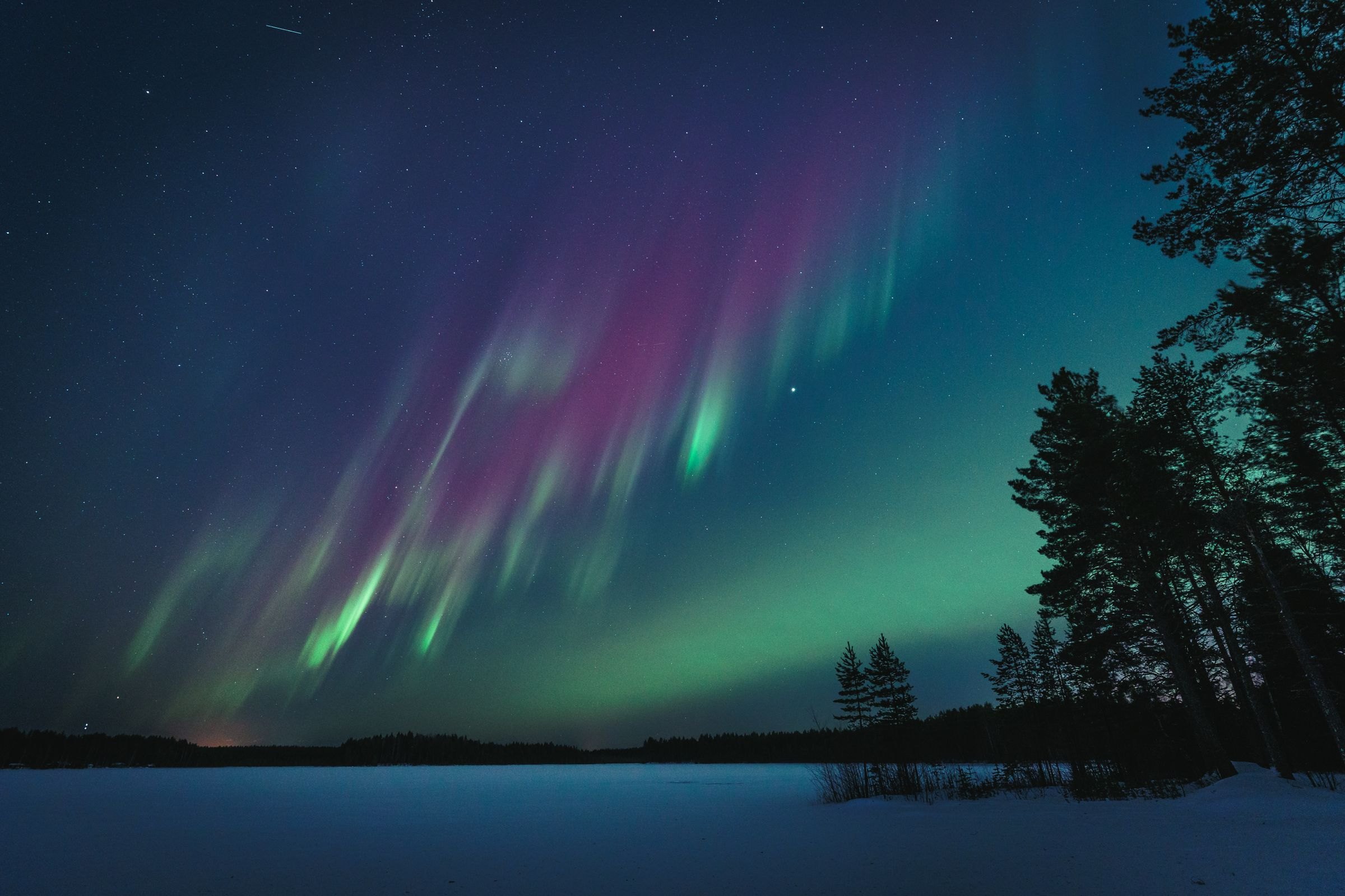 The Northern Lights over a lake in Finland