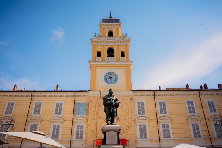 The clock tower and statue in Parma