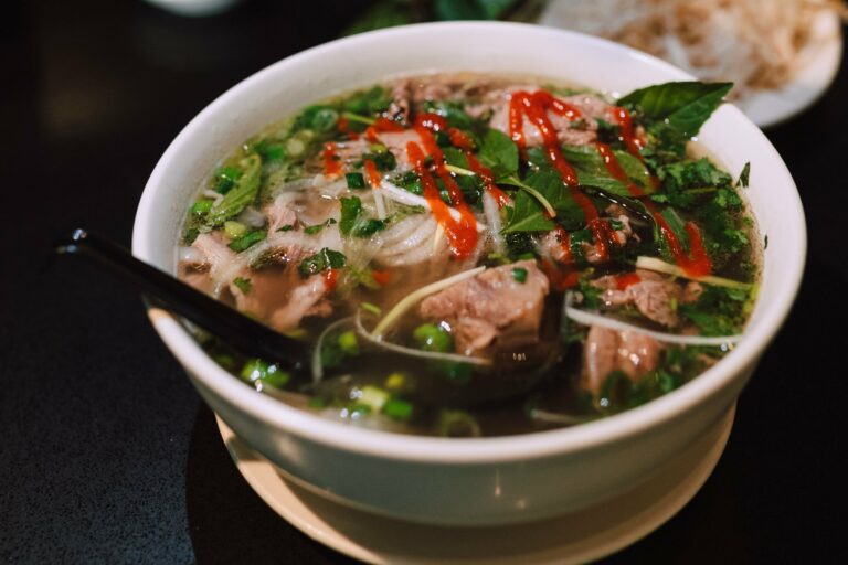A bowl of Vietnamese pho with fresh herbs