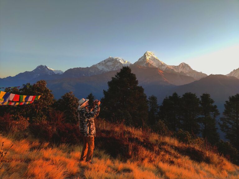 A walker photographing the Annapurna range at sunrise