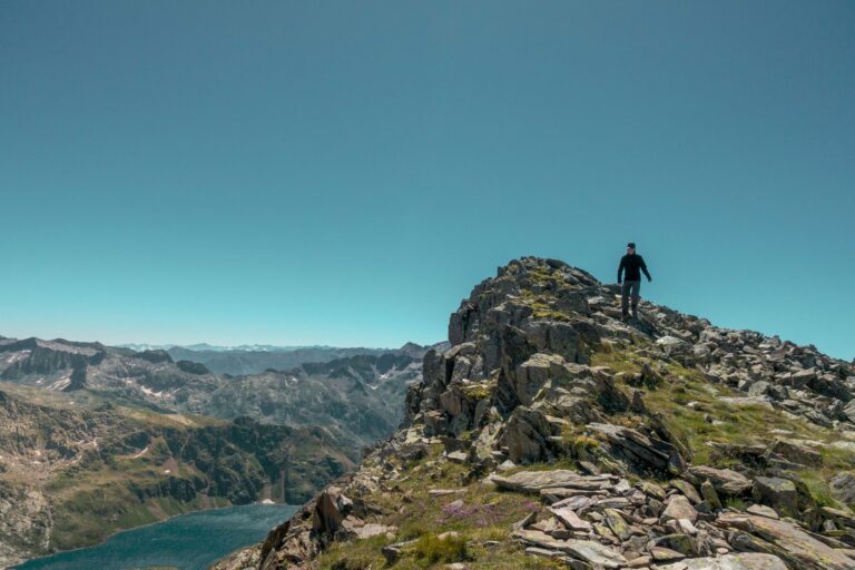 A hiker on a rocky ridge above a lake