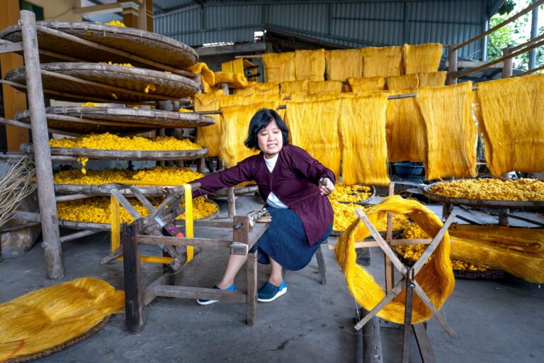 A woman spinning silk in a weaving workshop