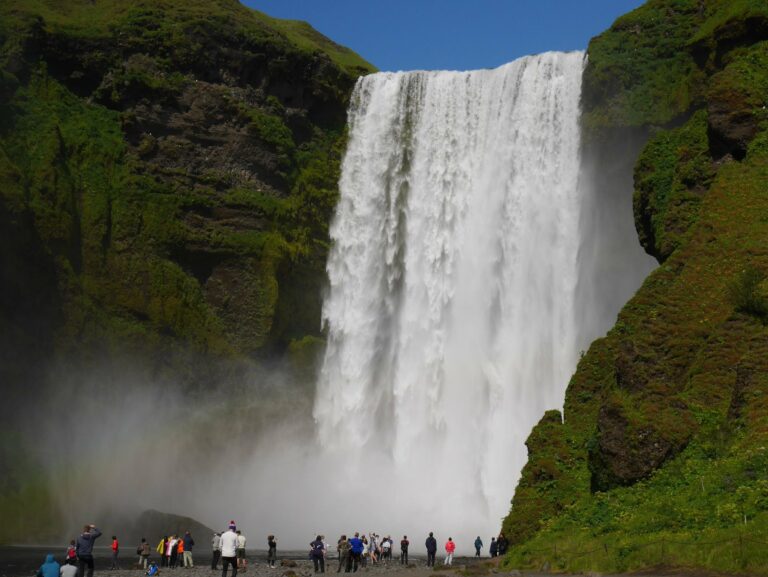 Visitors beneath the Skógafoss waterfall
