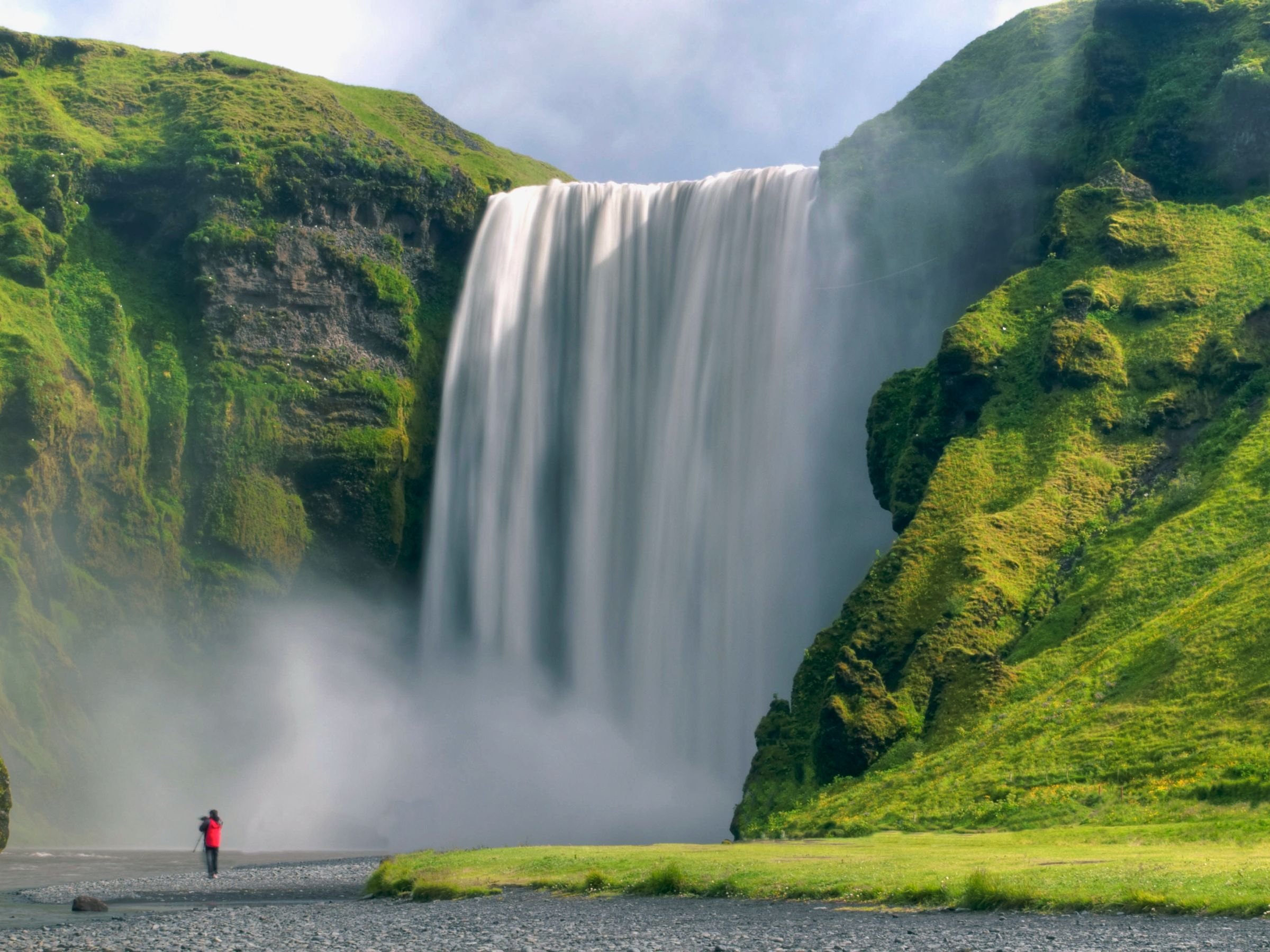 Skógafoss waterfall in green summer hills