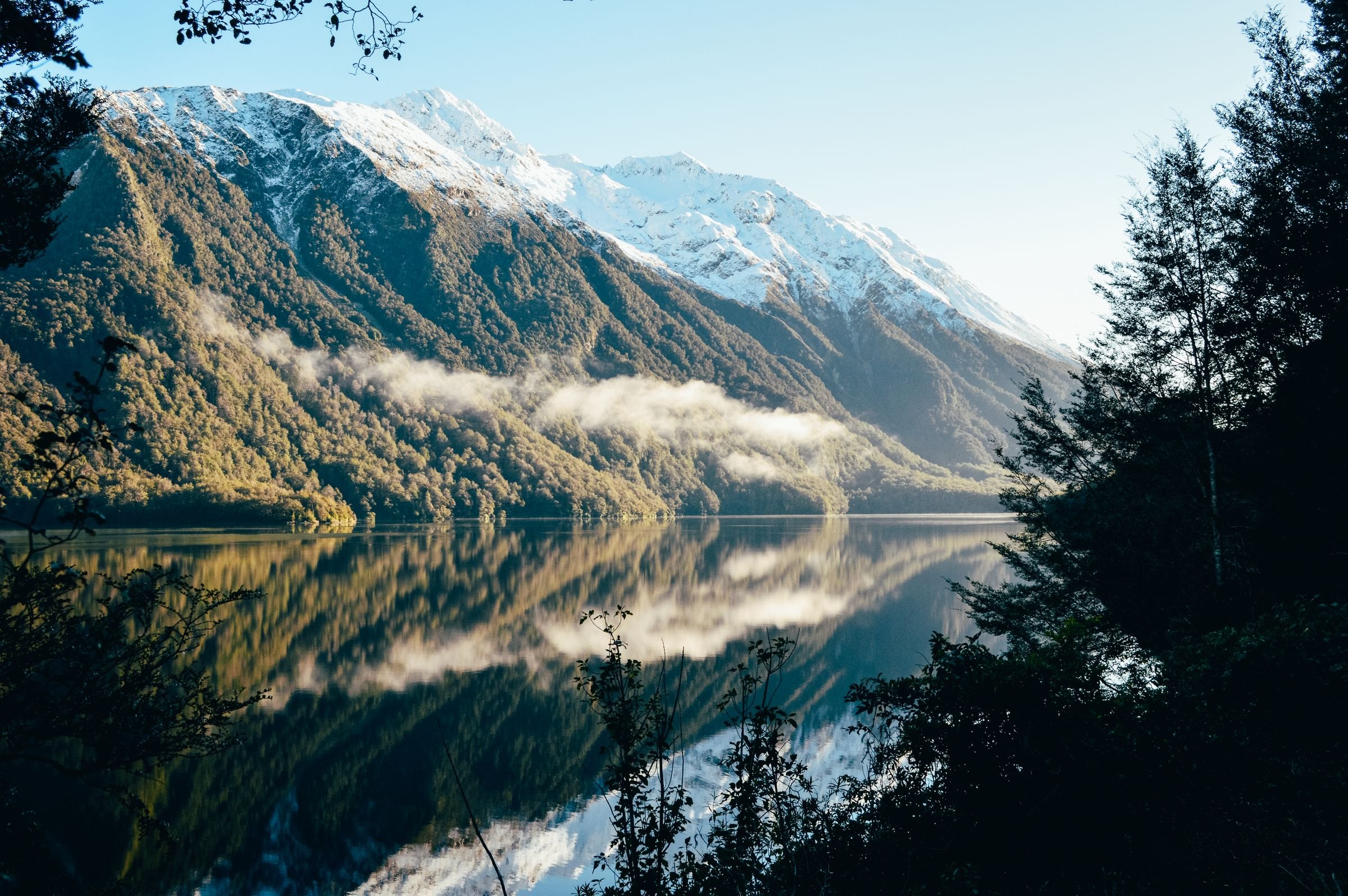 Snow-capped mountains reflected in a Fiordland lake