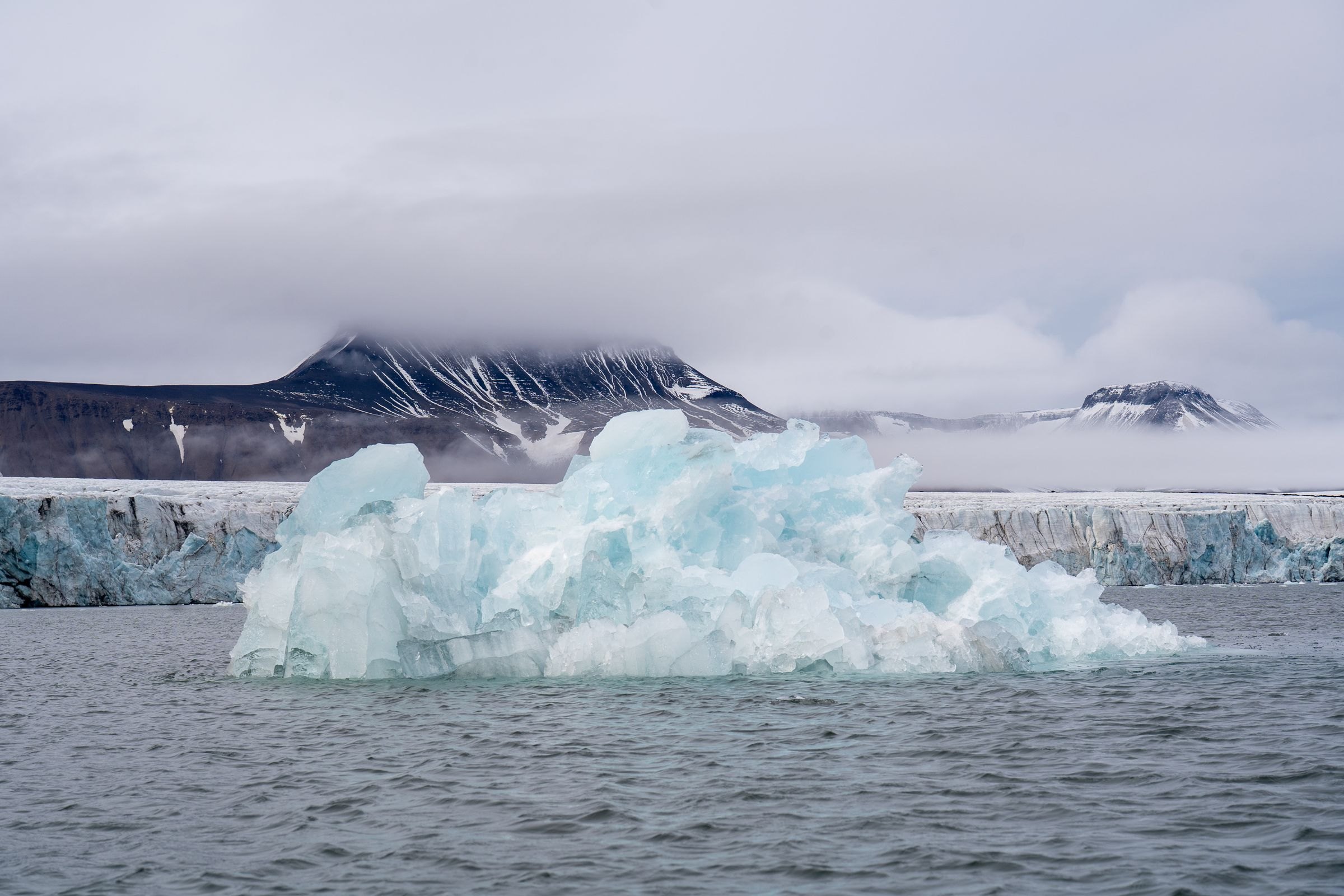 An iceberg below Svalbard's mountains