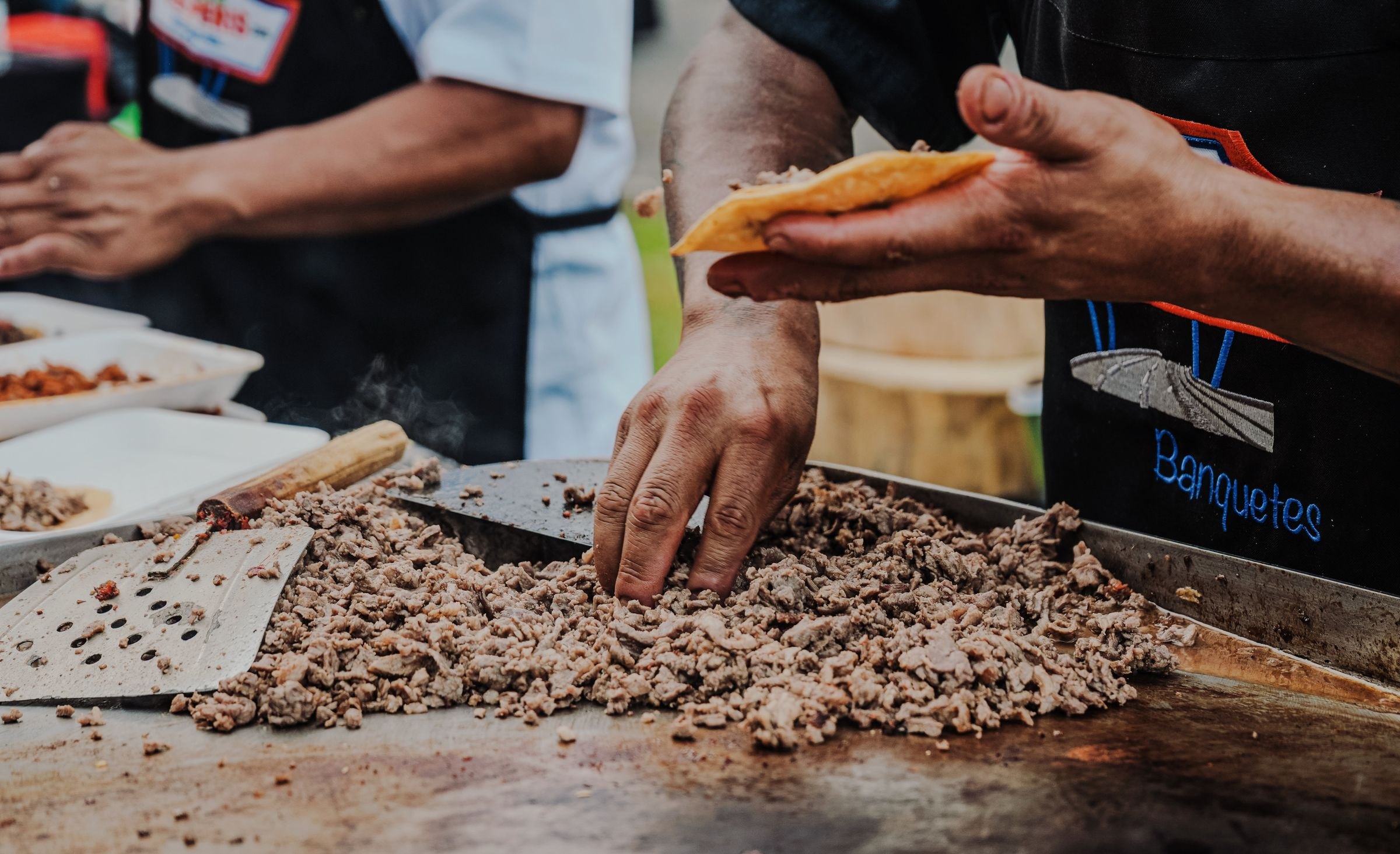 Tacos sizzling on a hot griddle