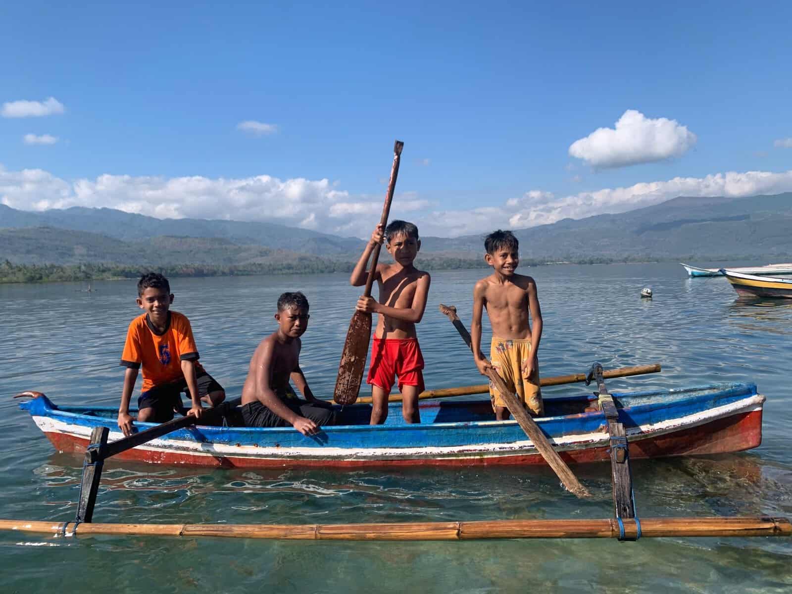 Boys in a canoe on a lake in Timor-Leste