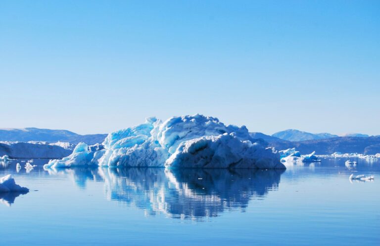 An iceberg reflected in calm water at Tiniteqilaaq