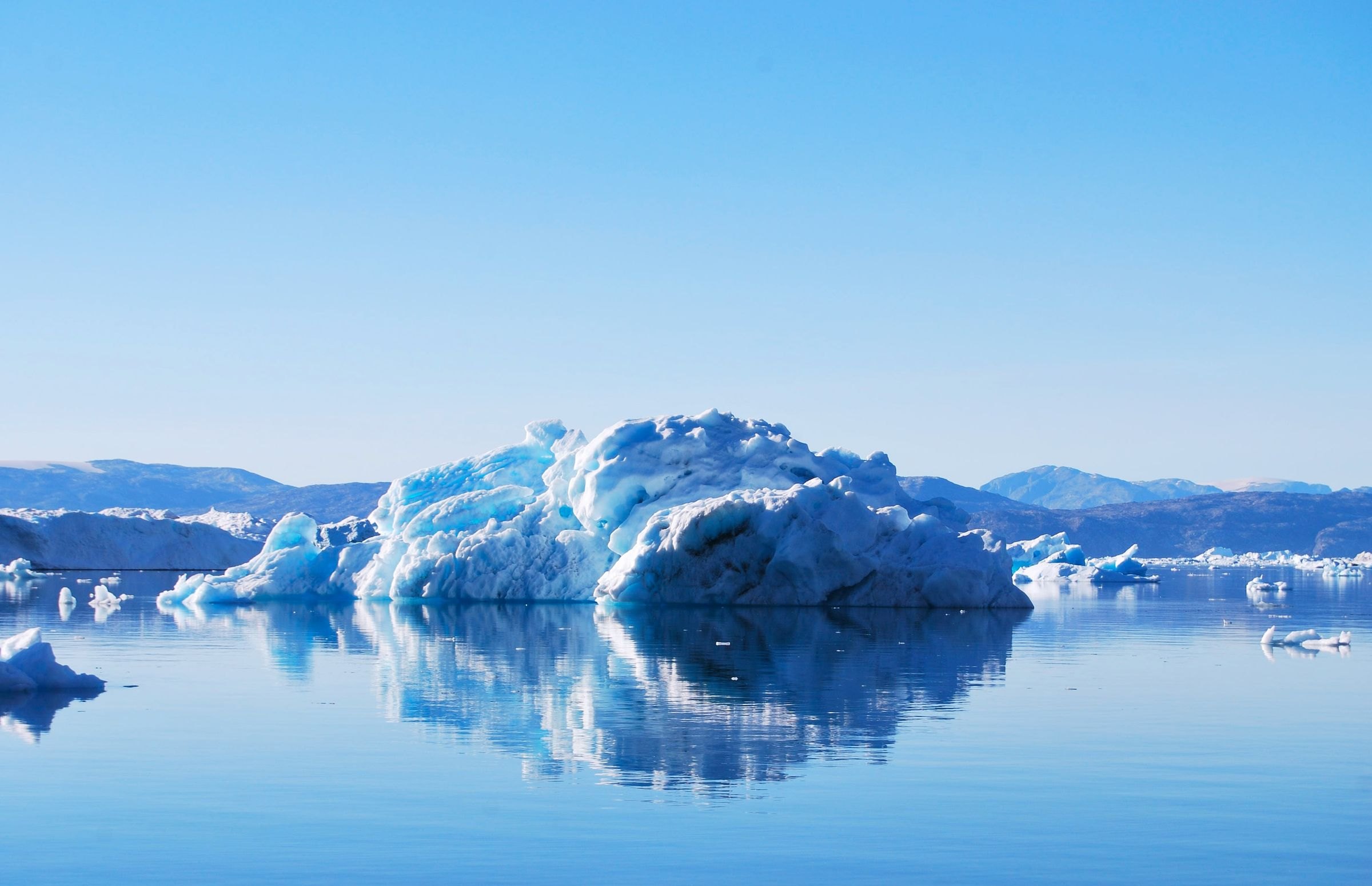 An iceberg reflected in calm water at Tiniteqilaaq