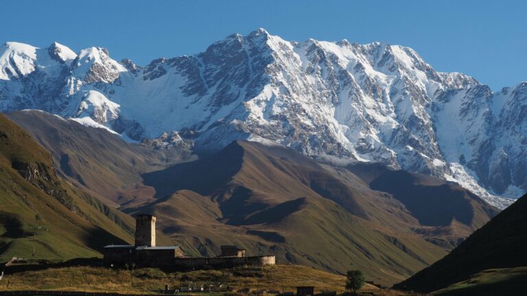 Ushguli's Svan towers below snowy peaks