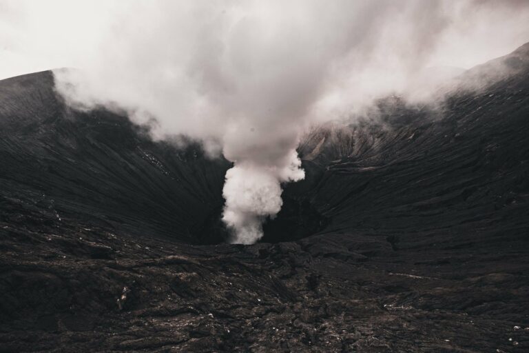 An active volcano crater billowing smoke