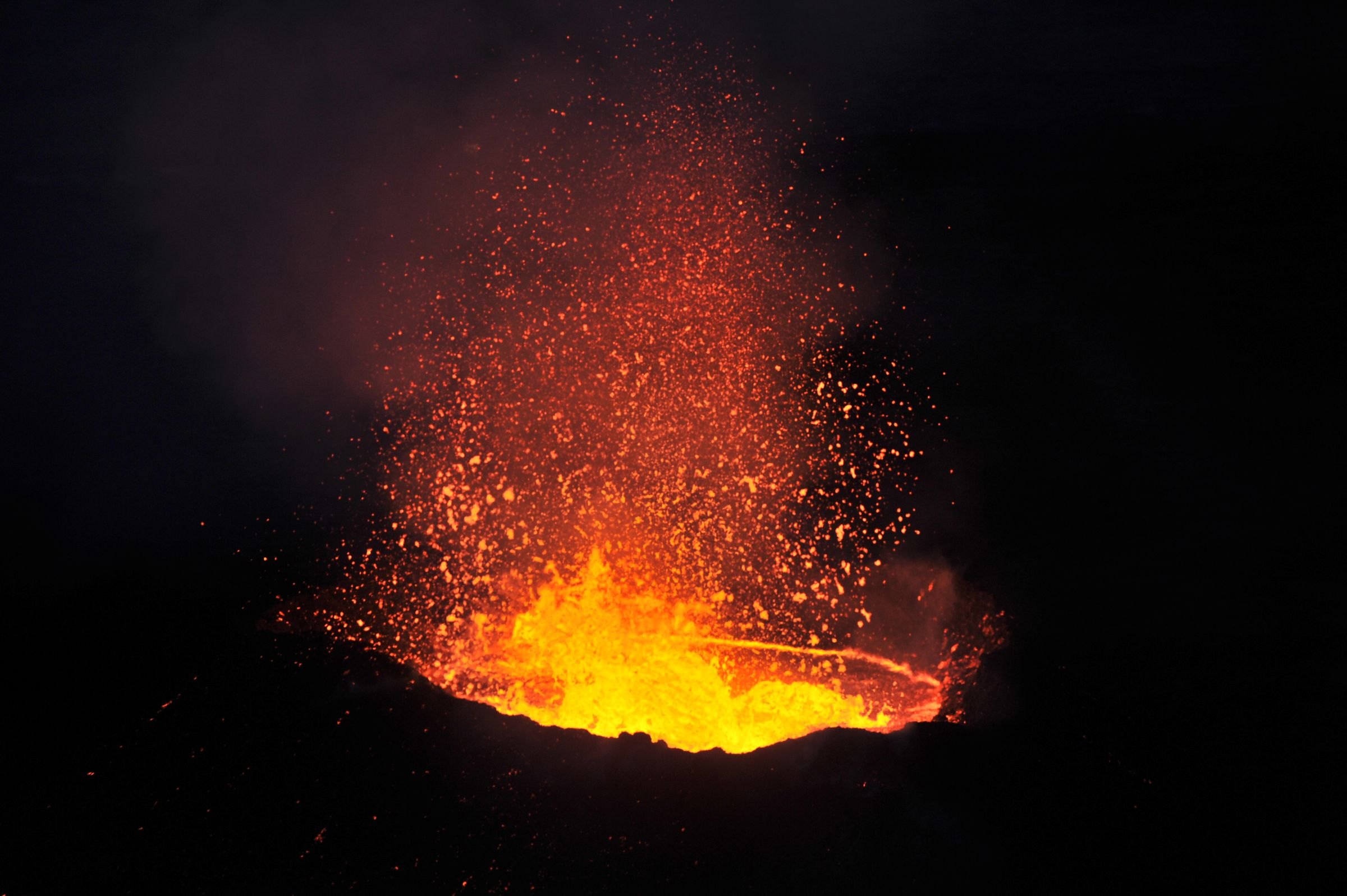 Lava erupting from a volcano at night