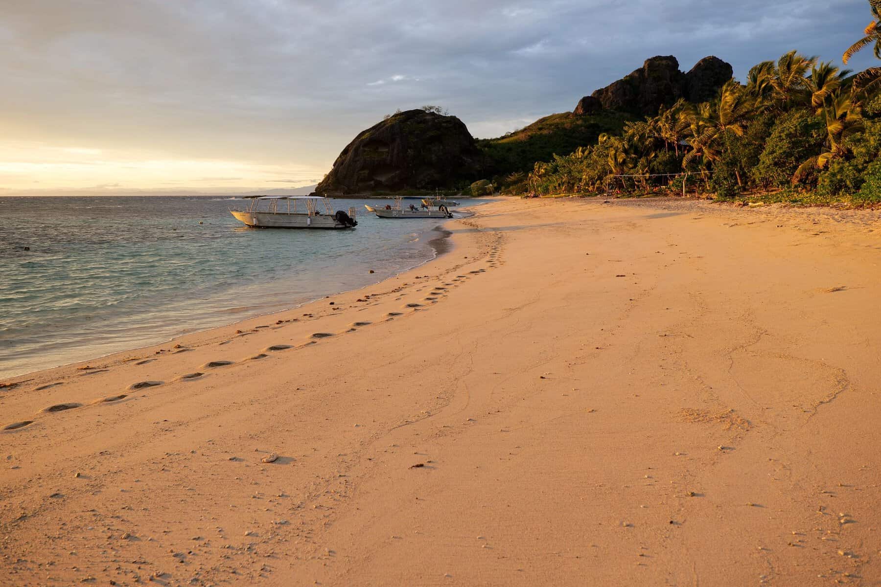 Boats and palm trees on a beach in the Yasawa Islands, Fiji