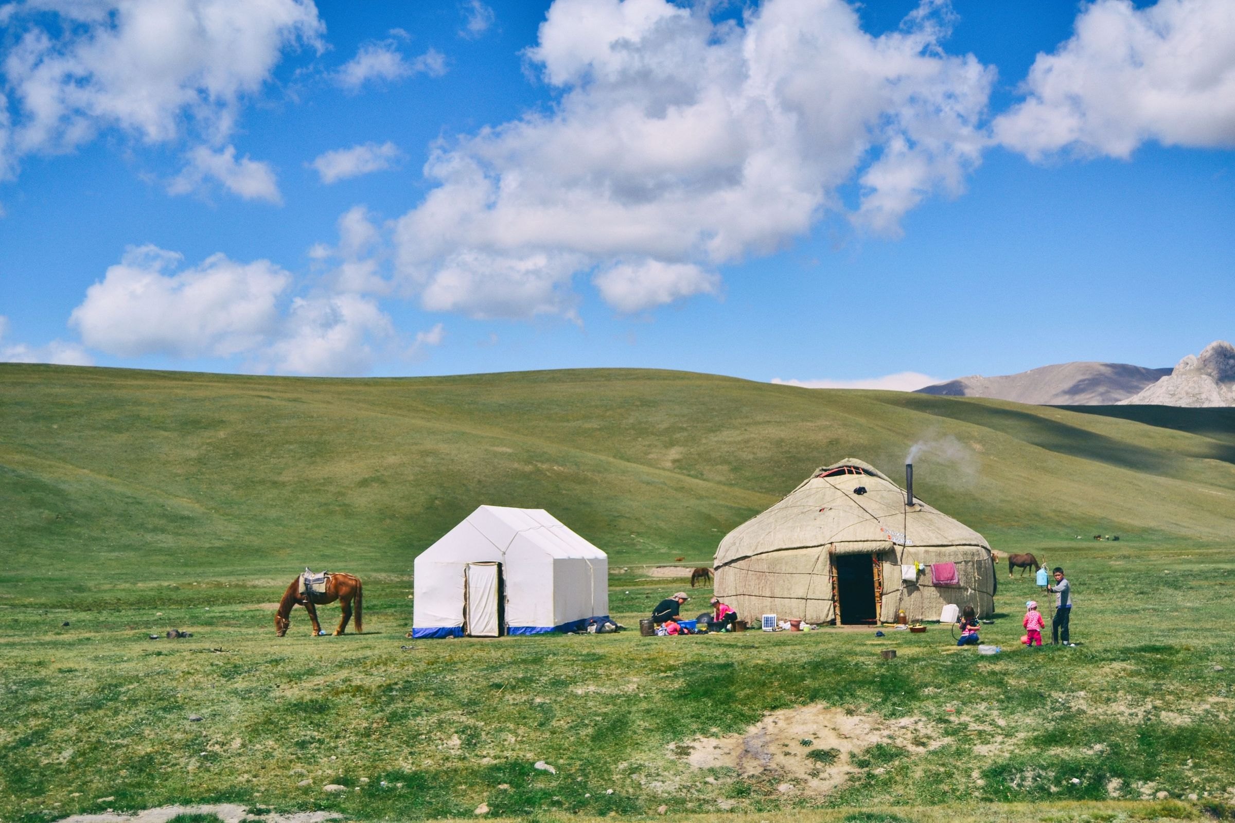 A yurt and grazing horse in the mountains